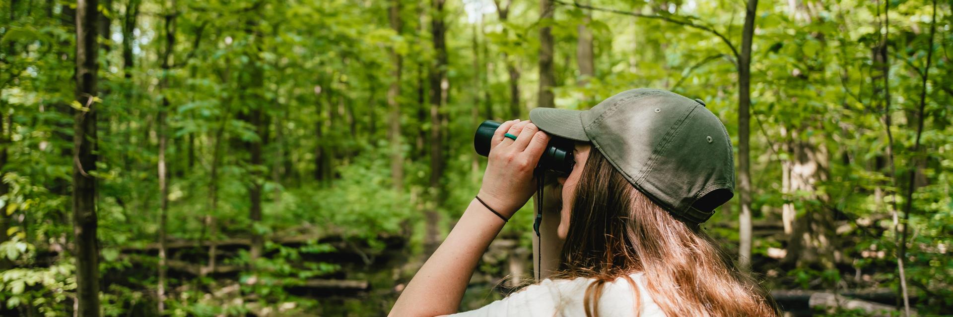 woman birdwatching in a park 