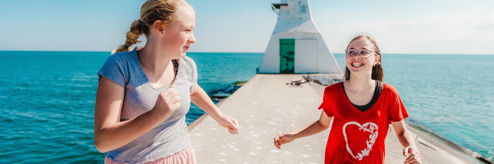 two girls running on erieau pier